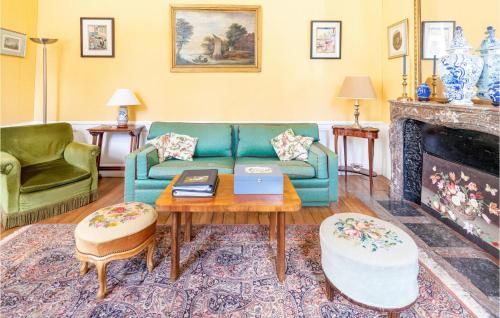 ein Wohnzimmer mit einer blauen Couch und einem Kamin in der Unterkunft 10 Bedroom Cozy Home In Allonne in Beauvais