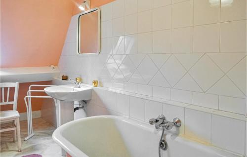 y baño con bañera blanca y lavamanos. en 10 Bedroom Cozy Home In Allonne en Beauvais