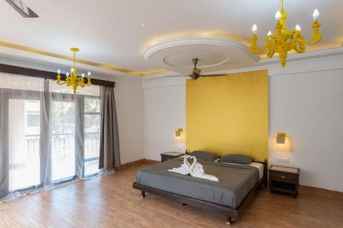 a bedroom with a bed and a yellow wall at Luxurious Villa with Private Swimming Pool, Kids Pool, Games, Private Parking in Calangute
