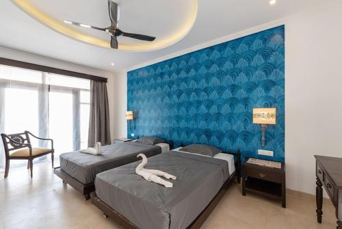 a bedroom with two beds with a white swan on them at Luxurious Villa with Private Swimming Pool, Kids Pool, Games, Private Parking in Calangute
