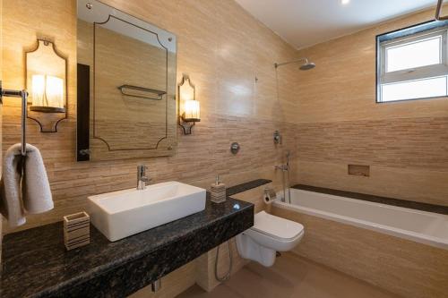 a bathroom with a sink and a toilet and a tub at Luxurious Villa with Private Swimming Pool, Kids Pool, Games, Private Parking in Calangute