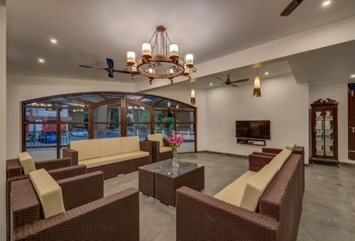 a living room with couches and a chandelier at Luxurious Villa with Private Swimming Pool, Kids Pool, Games, Private Parking in Calangute