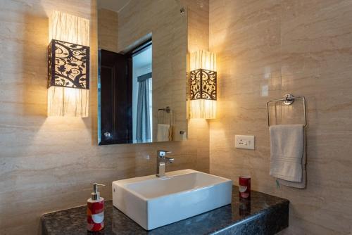 a bathroom with a white sink and a mirror at Luxurious Villa with Private Swimming Pool, Kids Pool, Games, Private Parking in Calangute