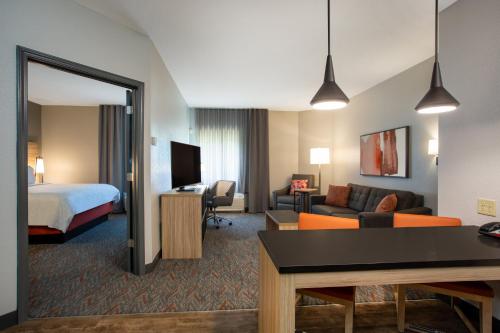 um quarto de hotel com uma cama e uma sala de estar em Candlewood Suites Apex Raleigh Area, an IHG Hotel em Apex