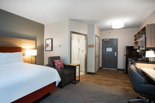 a hotel room with a bed and a desk and a chair at Candlewood Suites Apex Raleigh Area by IHG in Apex