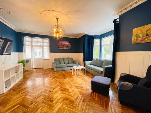 a living room with blue walls and wooden floors at aday - Aalborg City Center big apartment in Aalborg