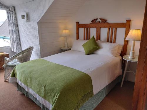 a bedroom with a large bed with a green blanket at Yellowwood Lodge in Knysna