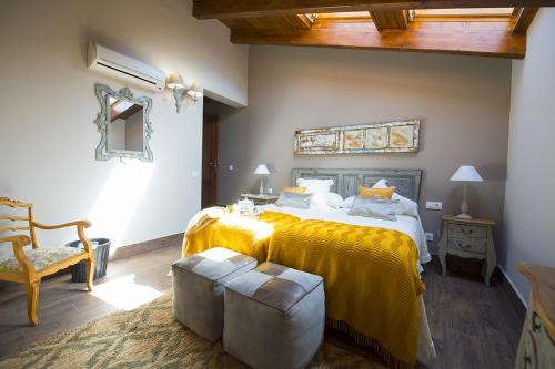 1 dormitorio con 1 cama grande con manta amarilla en Casa Rural Valle de la Laguna en Valdelaguna