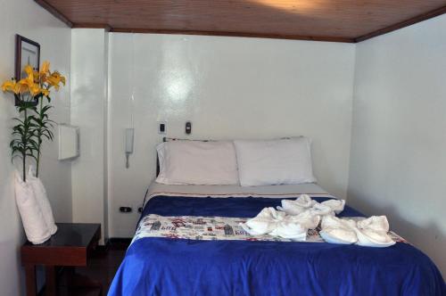 a bedroom with a bed with white shoes on it at Hotel Suite Imperial in Tunja
