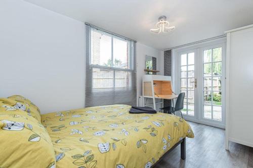 a bedroom with a bed and a desk and windows at Flat 3, 158 Abingdon Road in Oxford