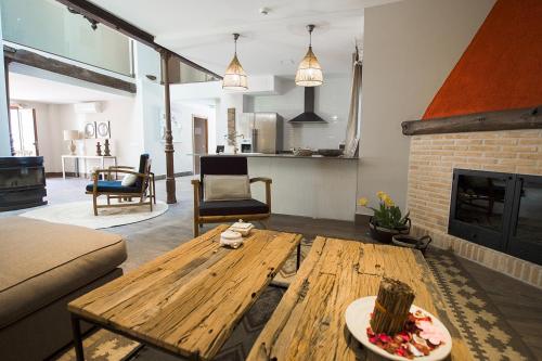 sala de estar con mesa de madera y chimenea en Casa Rural Valle de la Laguna en Valdelaguna