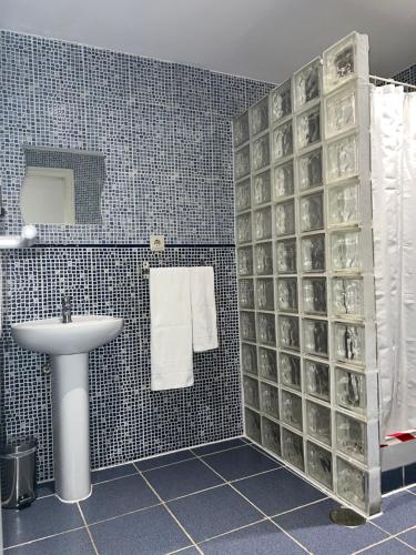 baño con lavabo y pared de cristal en Hostal Abaaly, en Madrid