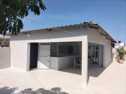 a small white house with a large patio at Maison d'Hôtes entière Cité Douane Golf Dakar in Dakar