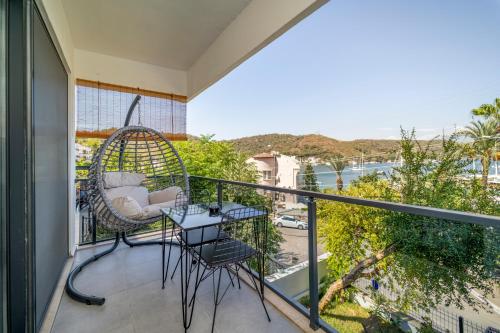 a balcony with a swing and a table and chairs at Nakas Suites in Fethiye