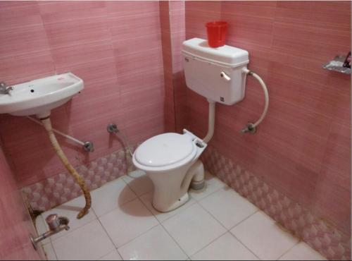 a bathroom with a toilet and a sink at Hotel Vijay by WB Inn in Kānpur