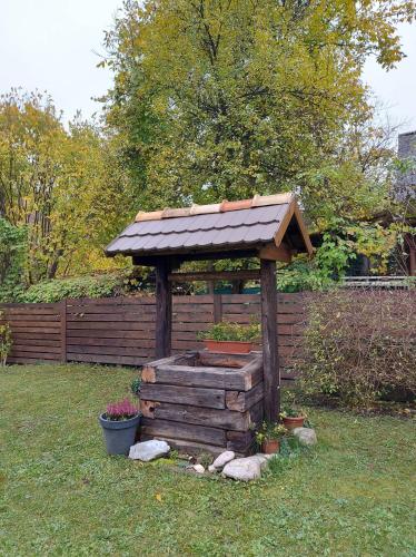 a wooden gazebo with a roof in a yard at Hámori Álom in Miskolc