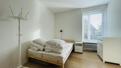 biała sypialnia z łóżkiem i oknem w obiekcie ApartmentInCopenhagen Apartment 1517 w Kopenhadze