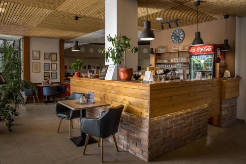 eine Bar in einem Restaurant mit einem Tisch und Stühlen in der Unterkunft Hotel Irottkö in Kőszeg