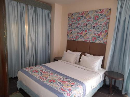 Porto Sharm Hotel Apartments Delmar for touristic investment في شرم الشيخ: غرفة نوم بسرير ودهان على الحائط