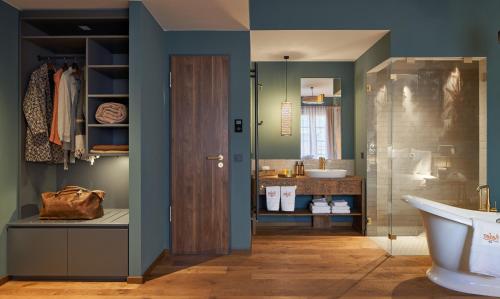 a bathroom with a toilet and a sink and a tub at Vabali Spa Hamburg Hotel in Glinde