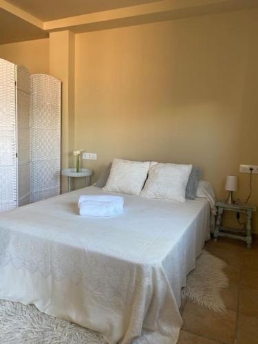 ein Schlafzimmer mit einem großen weißen Bett mit zwei Kissen in der Unterkunft Apartamento con piscina en Alicante, Beniarbeig in Beniarbeig