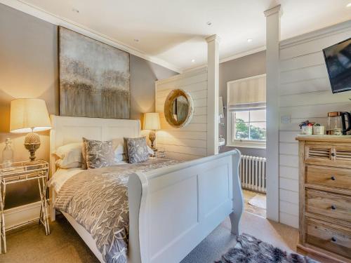 a bedroom with a large bed and a mirror at Willington Lodge in Hanmer