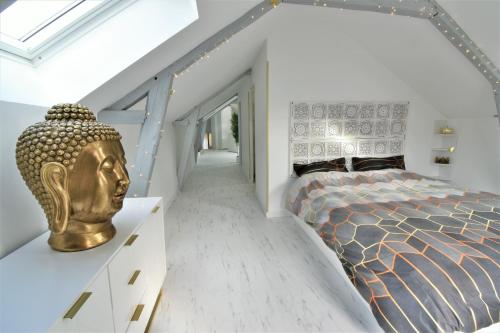 Un dormitorio con una cama con una cabeza de oro. en L'Or Blanc centre calme -15km d'Étretat, en Fécamp