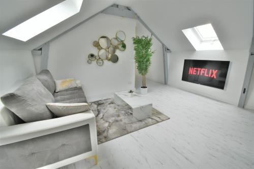 a living room with a couch and a tv at L'Or Blanc centre calme -15km d'Étretat in Fécamp