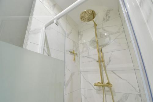 a shower with a glass door and a shower head at L'Or Blanc centre calme -15km d'Étretat in Fécamp