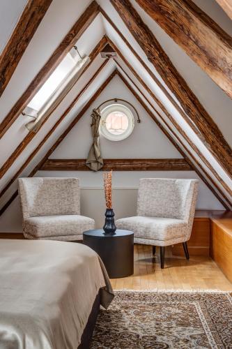 two chairs and a bed in a attic at Hotel Nerudova 211 in Prague
