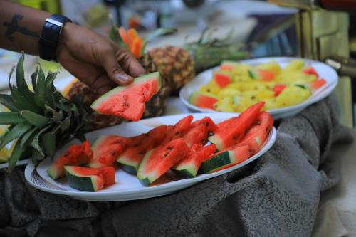 two plates of watermelon and fruit on a table at Sidra International Hotel in Addis Ababa