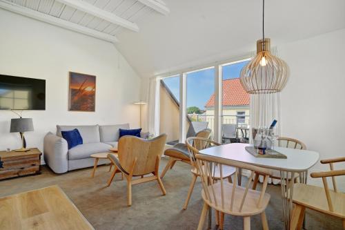 a living room with a table and chairs and a couch at Skagen Harbour Hotel in Skagen