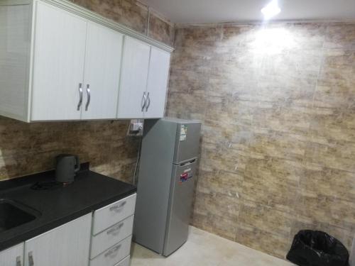 a kitchen with white cabinets and a refrigerator at المغتره للشقق الفندقيه in Ad Dawādimī