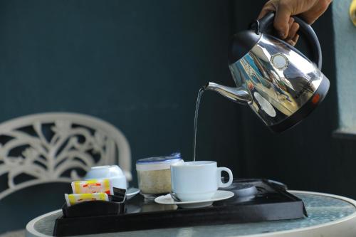 a person is pouring coffee into a cup on a tray at Sidra International Hotel in Addis Ababa