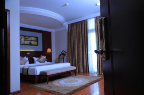 a bedroom with a bed and a bench in a room at Sidra International Hotel in Addis Ababa