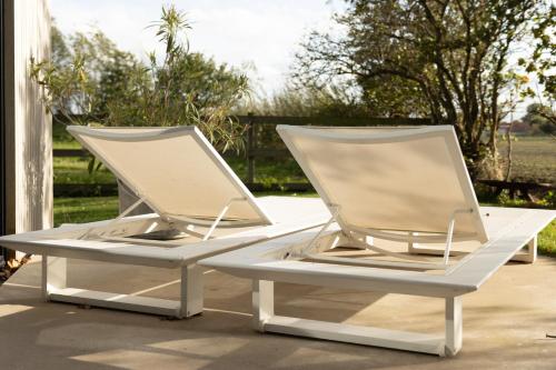 two white lounge chairs sitting on a patio at Rozeboom Loft in Aartrijke