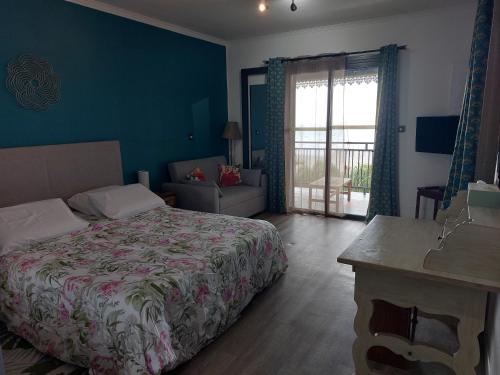 Nidamour, un logement fait pour vous في Saint-Paul: غرفة نوم مع سرير وغرفة معيشة
