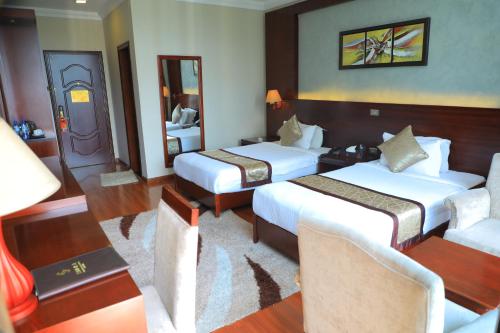 a hotel room with two beds and a couch at Sidra International Hotel in Addis Ababa