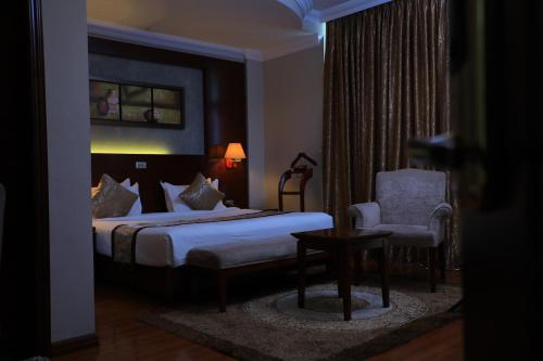 a hotel room with a bed and a chair at Sidra International Hotel in Addis Ababa