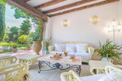 un patio con sofá, sillas y mesa en Cortijo Villa Padierna El Lago - Happy Rentals, en Estepona