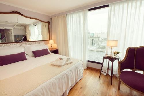 a bedroom with a large bed and a large mirror at Alma Histórica Boutique Hotel in Montevideo