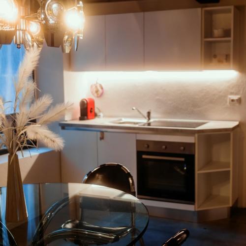 a kitchen with a table and a sink and a stove at HEATHER'S HOME 110 Apt 400mt from Old Bridge in Bassano del Grappa