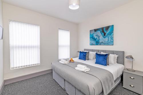 a bedroom with a large bed with blue pillows at 3 Bedroom Holiday Home Liverpool in Liverpool