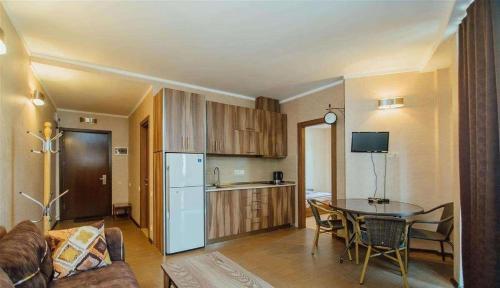 a living room with a table and a kitchen at Royal Apartments Batumi in Batumi