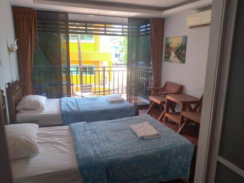 a hotel room with three beds and a balcony at Kamala bay inn in Kamala Beach