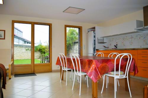 uma sala de jantar com uma mesa e cadeiras e uma janela em Le Break - maison de plain-pied avec jardin em Courseulles-sur-Mer