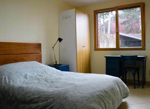 a bedroom with a bed and a desk and a window at Le Break - maison de plain-pied avec jardin in Courseulles-sur-Mer