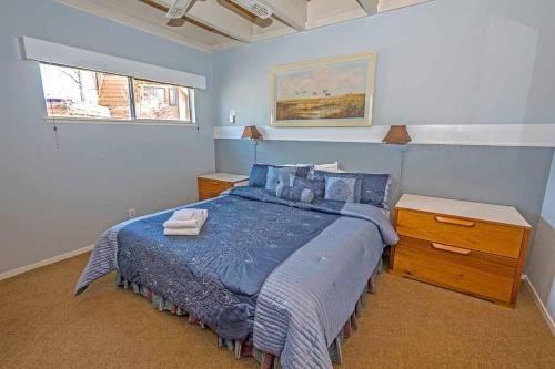 Un dormitorio con una cama con un edredón azul. en Ala Wai BoulevardApartment 23, en Lake Valley