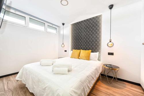 1 dormitorio con 1 cama blanca grande con almohadas amarillas en Aloe encantador close to yumbo and dunas, en Maspalomas