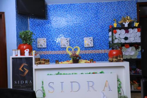 a table with a sign in front of a blue wall at Sidra International Hotel in Addis Ababa